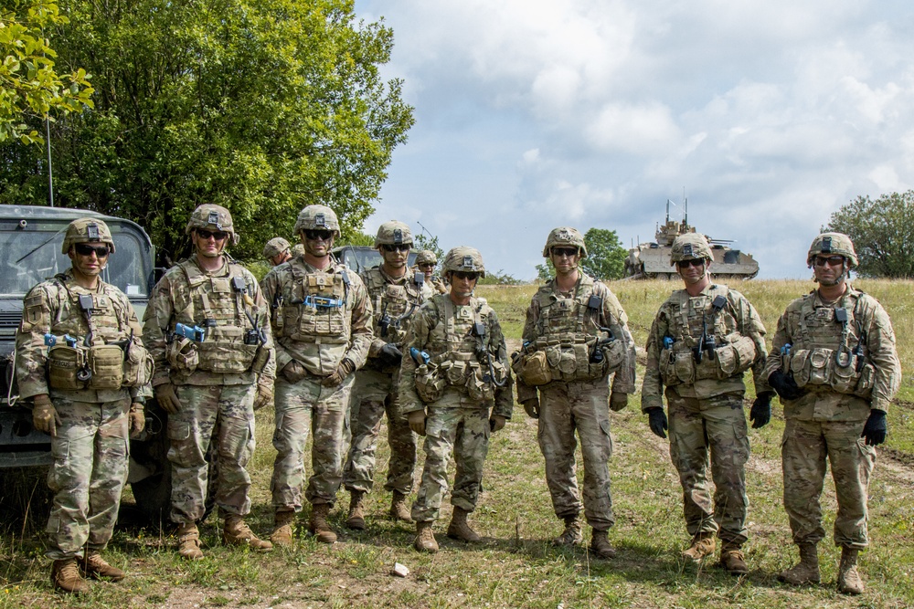 Observer Controller Trainers assigned to the Joint Multinational Readiness Center (JMRC) pose for a picture during a Combined Resolve training exercise in Grafenwoehr Training Area, August, 8, 2019.