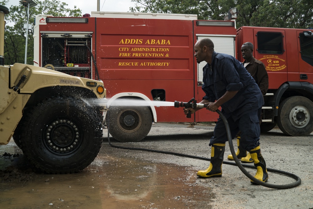 Ethiopian firefighters spray muddy Humvee