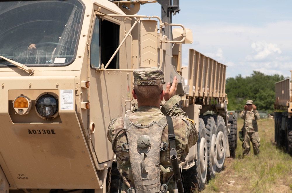 Soldier ground guides a palletized load system vehicle