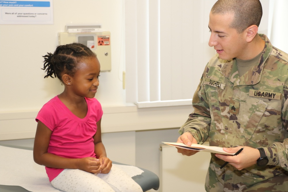 Medic takes child's vitals during back-to-school event in Baumholder