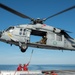 An MH-60S Sea Hawk prepares to lift ammunition from the flight deck