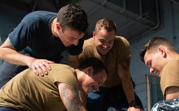 U.S. Sailors splice an eye into mooring lines.