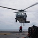 U.S. Sailors attach ammunition to an MH-60S Sea Hawk