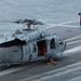 U.S. Sailor signals to fuel an aircraft