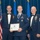 Airman Leadership School distinguished graduate Three United States Air Force personnel pose for a formal photograph at what appears to be an Airman Leadership School graduation ceremony. The central figure holds a framed diploma from the United States Air Force Airman Leadership School and wears a graduation medal around his neck. The two flanking individuals wear dress uniforms with bow ties and display senior NCO rank insignia and multiple service ribbons.