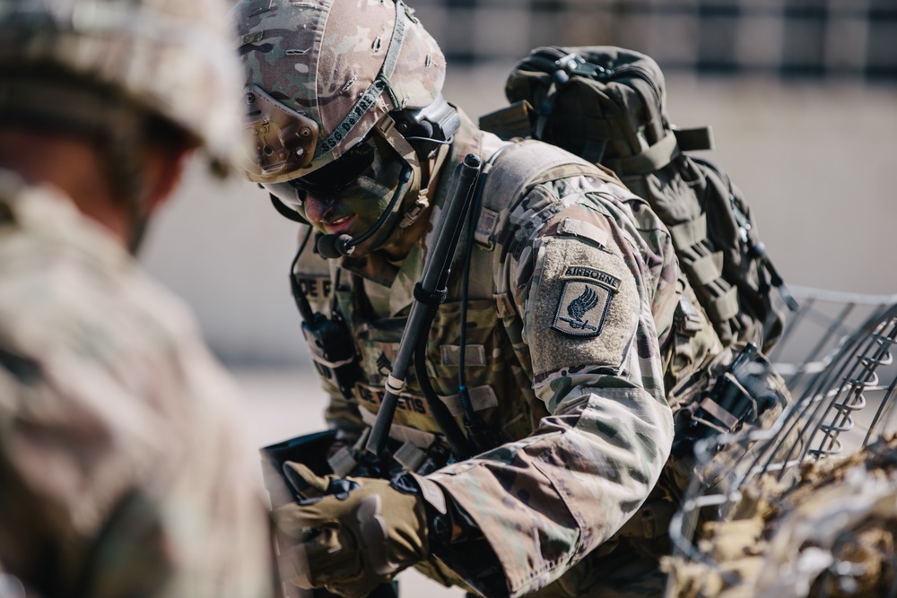 U.S. Army paratrooper navigates a concertina wire fence
