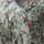 Two U.S. Navy personnel are shown wearing the Navy Working Uniform (NWU Type III) in green digital camouflage pattern. One sailor has a medal being pinned to their chest, suggesting an awards ceremony or commendation event. Visible insignia and badges indicate a formal military recognition occasion.