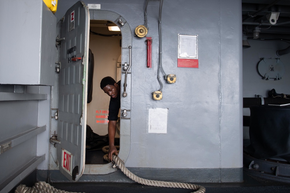 U.S. Navy Sailor moors lines on the aircraft carrier USS John C. Stennis
