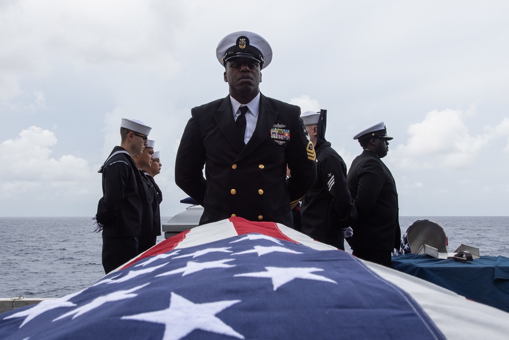 U.S. Navy Master Chief Operation’s Specialist Mark Bell, from Birmingham, Alabama, stands at parade rest during a burial at sea