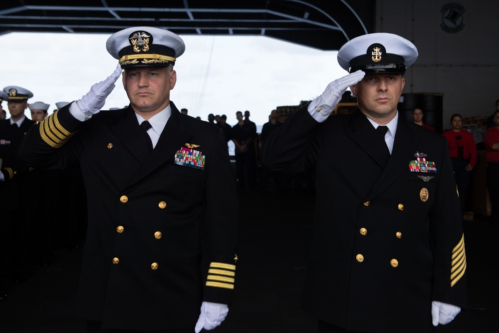 U.S. Navy Capt. Randy Peck, left, commanding officer of the aircraft carrier USS John C. Stennis (CVN 74), and Command Master Chief Benjamin Rushing salute during a burial at sea