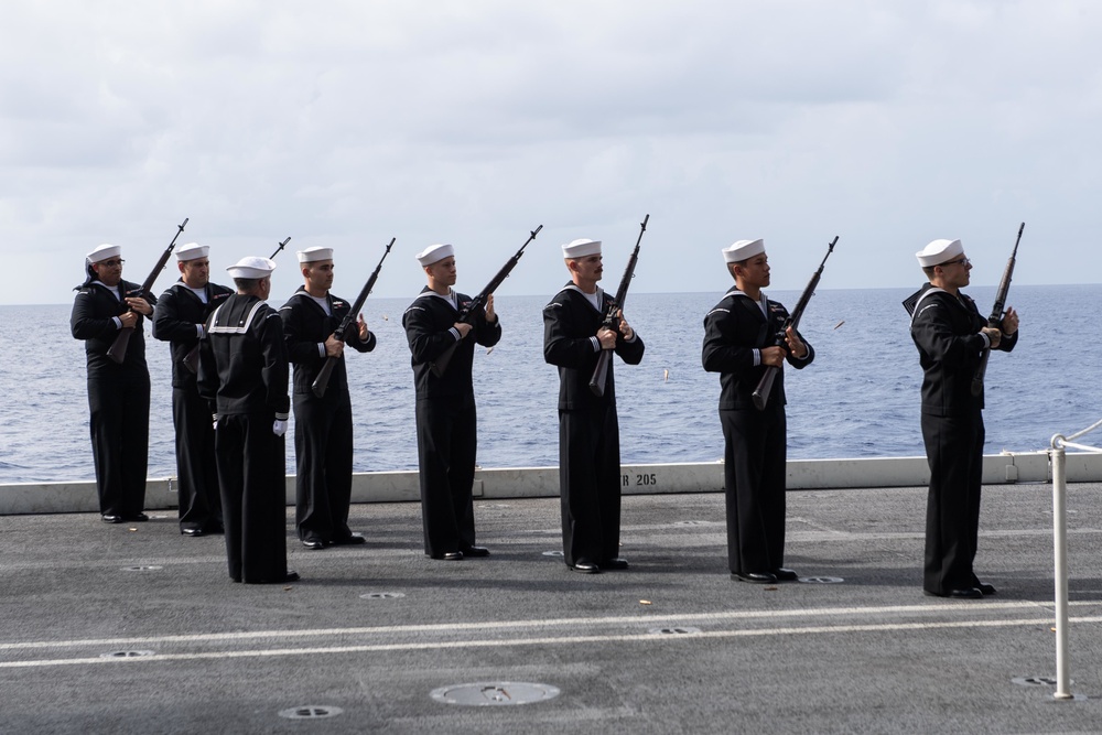U.S. Sailors conduct a 21-gun salute during a burial at sea