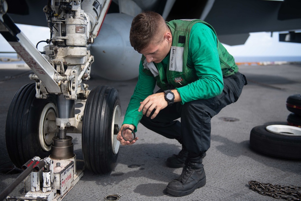 U.S. Navy Sailor conducts maintenance on F/A-18F Super Hornet aboard the aircraft carrier USS John C. Stennis