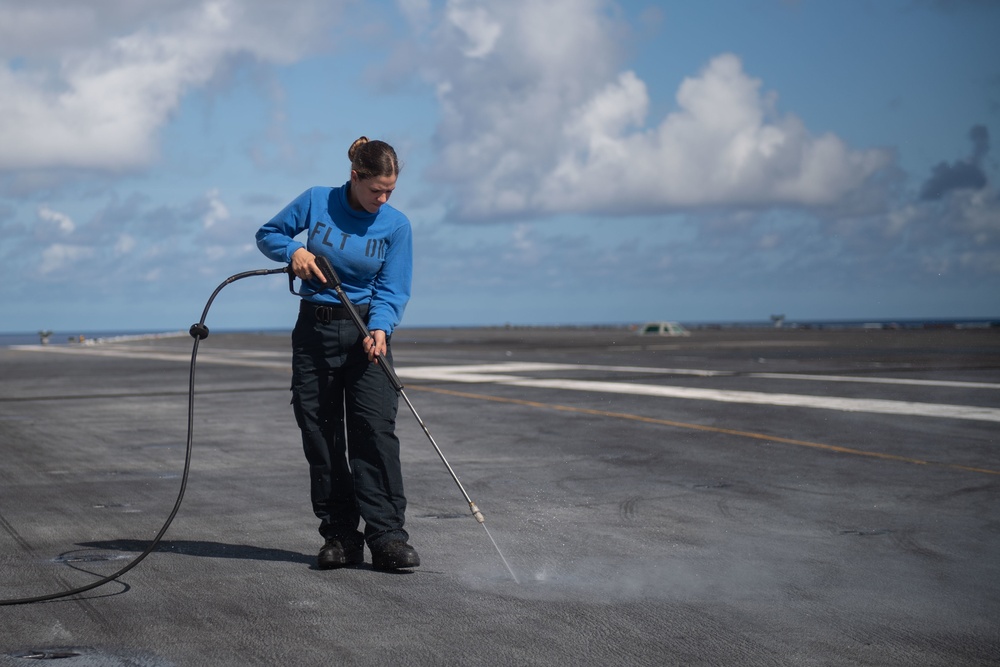 U.S. Navy Sailor cleans pad-eye on flight deck of the aircraft carrier USS John C. Stennis