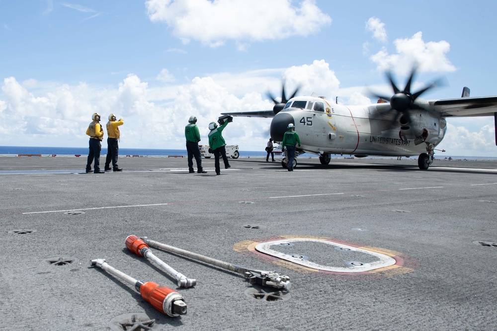 U.S. Sailors direct a C-2A Greyhound, assigned to Fleet Logistics Combat Support Squadron (VRC) 40, on the flight deck