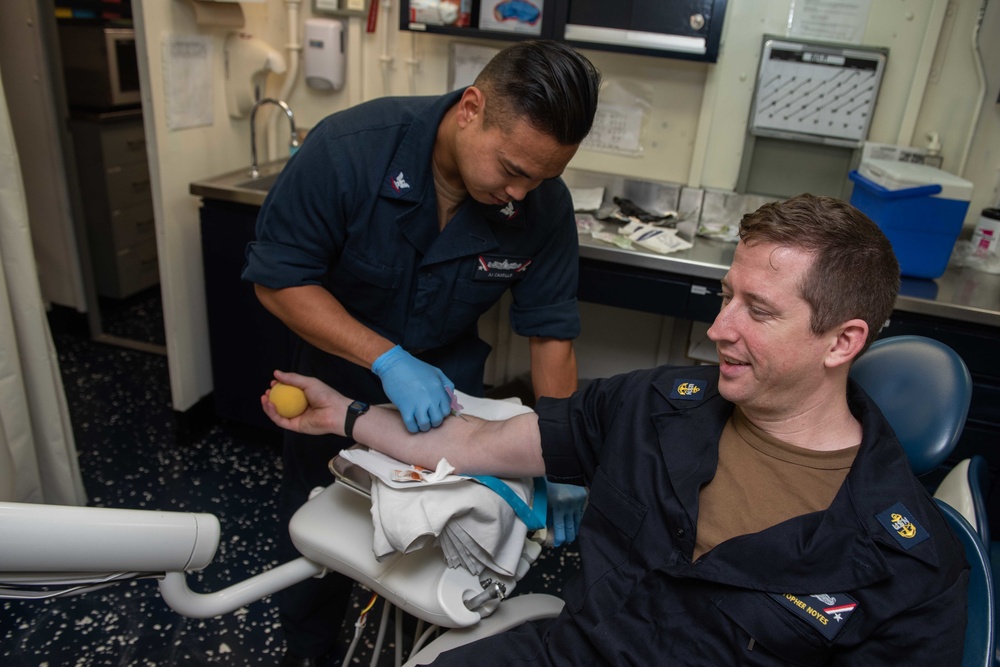 U.S. Sailor draws blood from patient