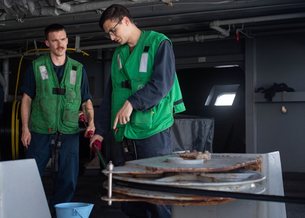 U.S. Sailors rinse a cable for a torpedo countermeasure system