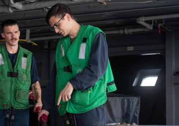 U.S. Sailors rinse a cable for a torpedo countermeasure system
