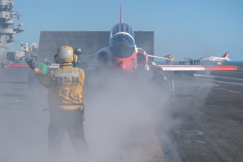 U.S. Sailor directs a T-45C Goshawk jet attached to Chief of Naval Air Training Command for launch off the flight deck of the aircraft carrier USS John C. Stennis