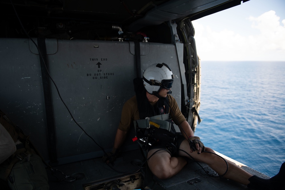 U.S. Navy Aircrewman (Helicopter) prepares for a vertical replenishment-at-sea exercise with an MH-60S Sea Hawk on the flight deck of the aircraft carrier USS John C. Stennis
