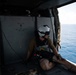 U.S. Navy Aircrewman (Helicopter) prepares for a vertical replenishment-at-sea exercise with an MH-60S Sea Hawk on the flight deck of the aircraft carrier USS John C. Stennis
