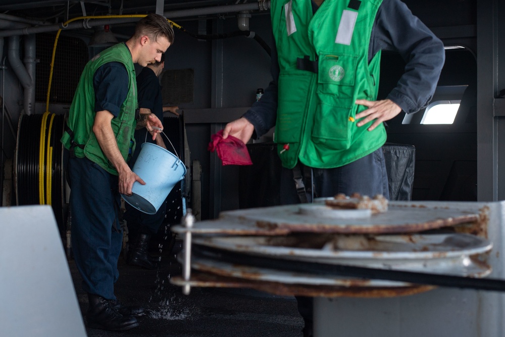 U.S. Sailors rinse a cable for a torpedo countermeasure system