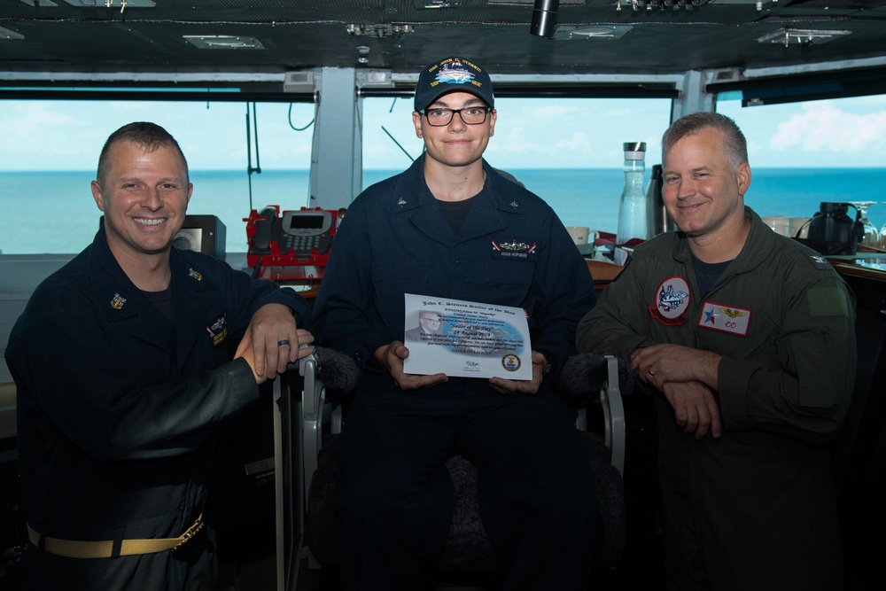 Sailor of the Day takes a photo with the captain and command master chief of the USS John C. Stennis