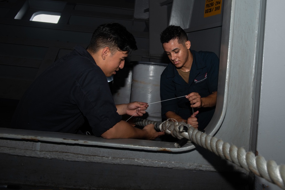 U.S. Navy Boatswain's Mate Seaman Jason Purdy, left, from Honolulu, and Seaman Apprentice Obrian Garcia-Jimenez, from Vayamon, Puerto Rico, whip new line on a mooring line