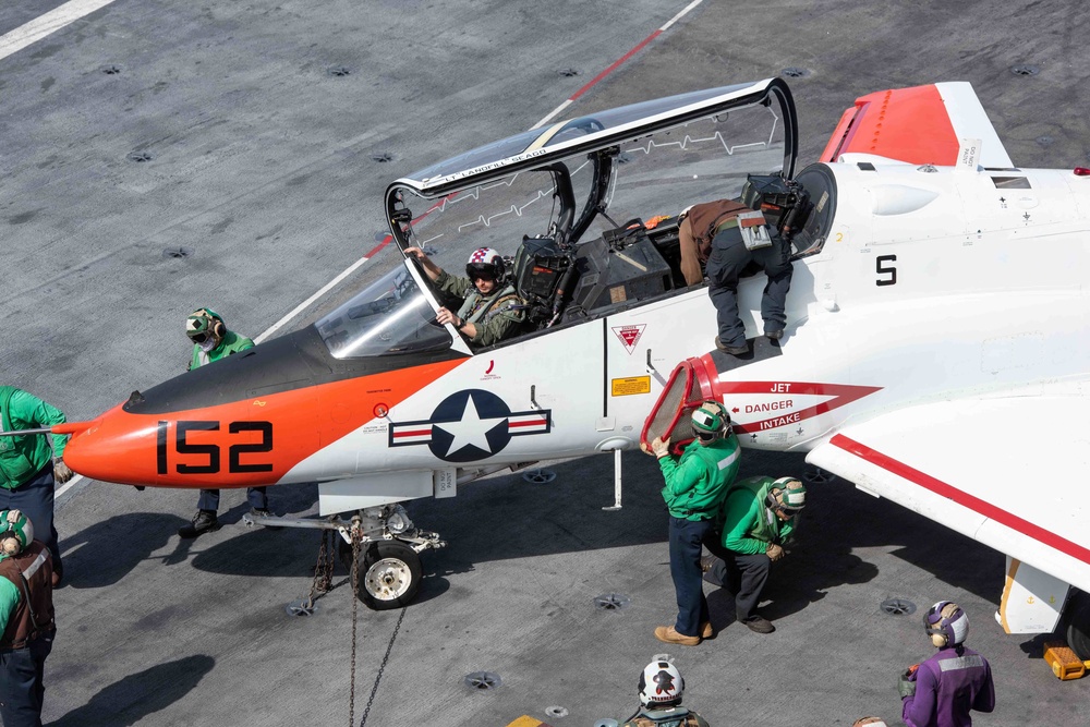U.S. Sailors perform a turnaround inspection on a T-45C Goshawk training aircraft.
