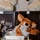 A light blue storage box labeled '4lbs' sits on a yellow surface, containing a brown fox/bear stuffed animal, tissue paper, a greeting card with floral decoration, and what appears to be a printed information sheet. Behind it are dark gift bags with partial text reading 'fill my heart' and patterned fabric items visible at the top. This appears to be a charitable donation or care package setup, likely for premature or low-birth-weight infants.
