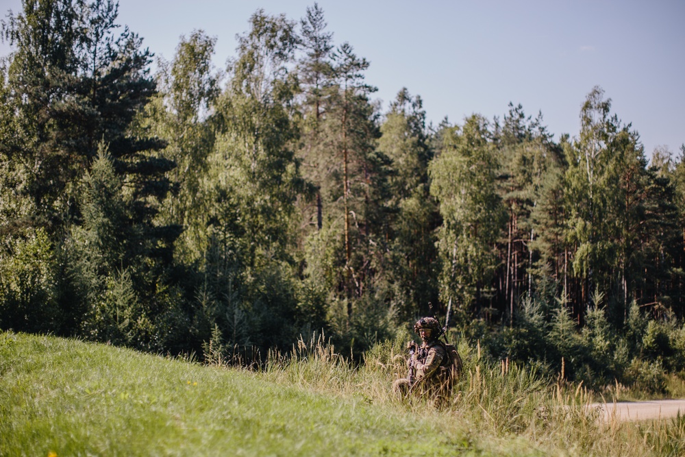 U.S. Army paratrooper screens lane for enemy movement