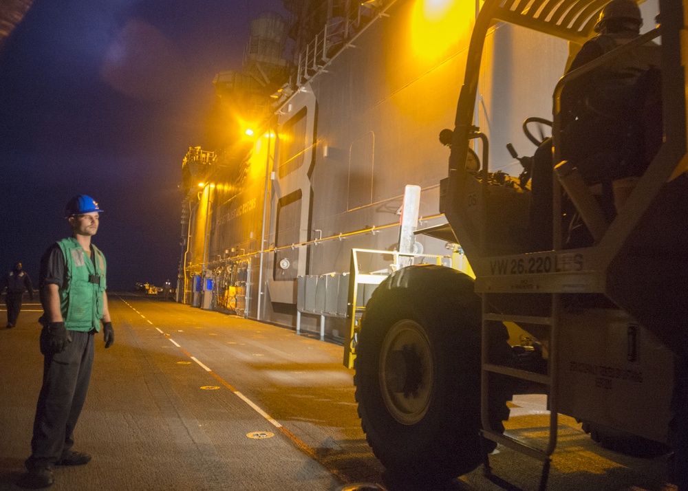 USS Makin Island Sailors Transfer Equipment at Night