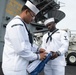 U.S. Navy Sailors fold the American flag on the flight deck of the aircraft carrier USS John C. Stennis (CVN 74) as the ship prepares to depart Norfolk, Virginia