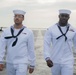 U.S. Navy Sailors march across the flight deck of the aircraft carrier USS John C. Stennis (CVN 74) to lower the American flag as the ship prepares to depart Norfolk, Virginia