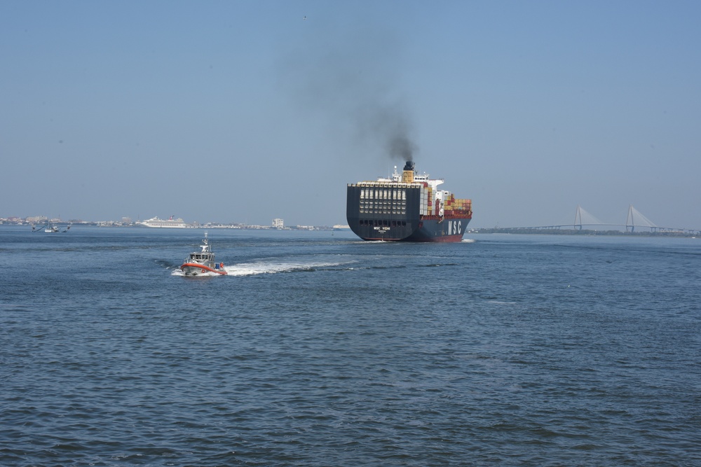A crew from Coast Guard Station Charleston patrols Charleston Harbor as a cargo ship heads into the Port of Charleston