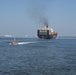 A crew from Coast Guard Station Charleston patrols Charleston Harbor as a cargo ship heads into the Port of Charleston