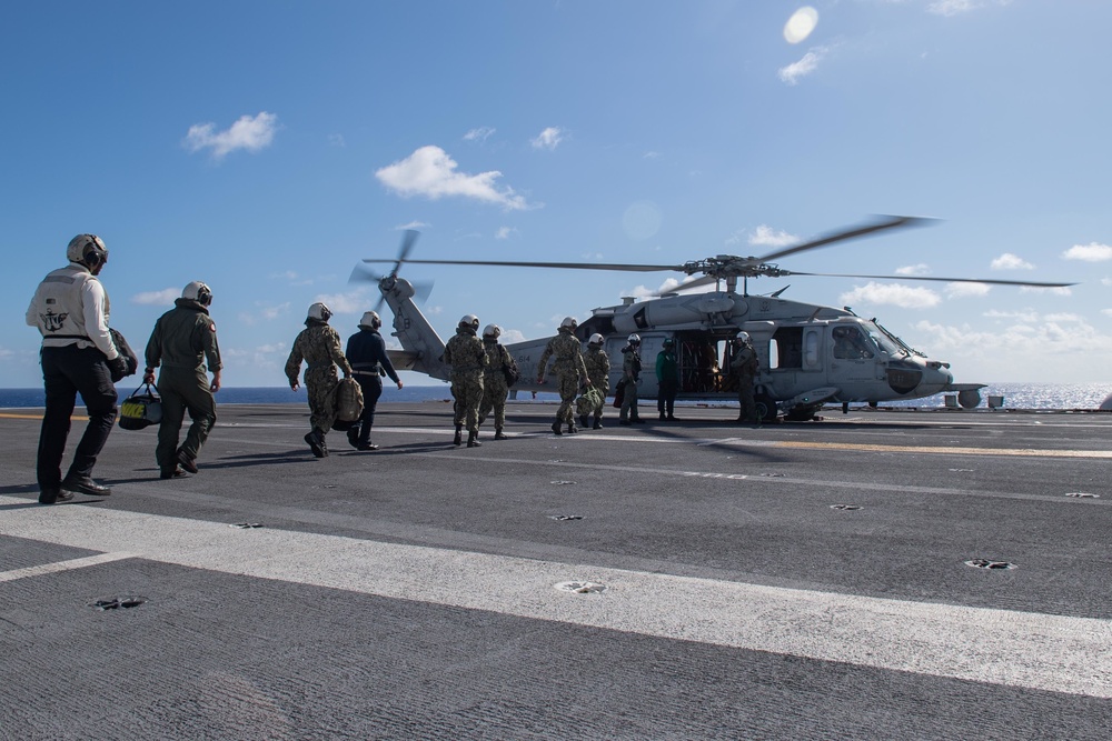 U.S. Sailors prepare to board an aircraft