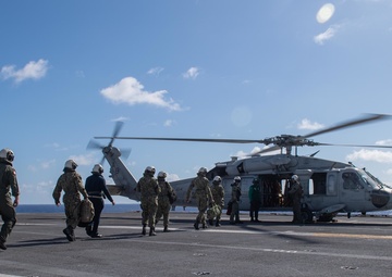U.S. Sailors prepare to board an aircraft