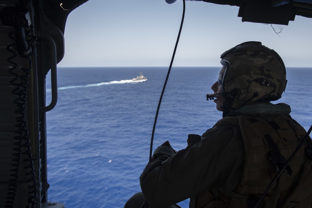 U.S. Navy Naval Air Crewman (Helicopter) watches from an MH-60S Sea Hawk as the crew prepares to land on the flight deck of the aircraft carrier USS John C. Stennis (CVN 74) in the Atlantic Ocean, Sept. 7, 2019