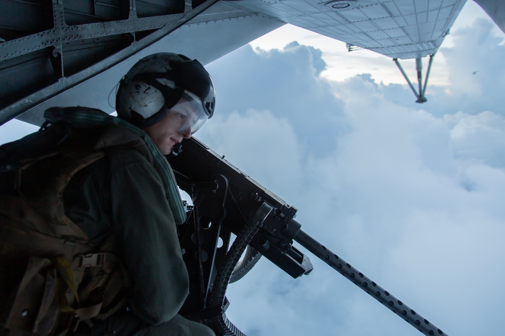 US Marine mans a 50 caliber heavy machine gun during an evening flight