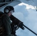 US Marine mans a 50 caliber heavy machine gun during an evening flight