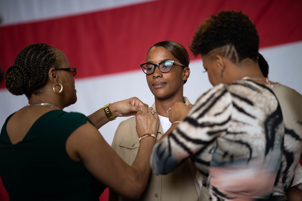 U.S. Navy Chief Quartermaster Courtney Brown receives her chief petty officer (CPO) anchors from family members  during a CPO pinning ceremony