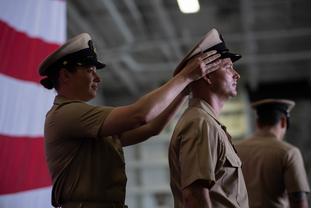 U.S. Navy Chief Aviation Boatswain's Mate (equipment) Brendan Fagan, receives his chief petty officer (CPO) combination cover from Senior Chief Mass Communication Specialist Holly Gray, during a CPO pinning ceremony