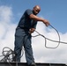 U.S. Navy Airman Apprentice Caleb Sims, from Bromulus, Michigan, untangles the wire from the Union Jack flag pole on the flight deck of the aircraft carrier USS John C. Stennis