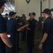 U.S. Navy Sailors pass resin barrels