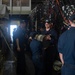 U.S. Navy Sailors pass resin barrels