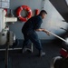 U.S. Navy Sailor heaves in a mooring line