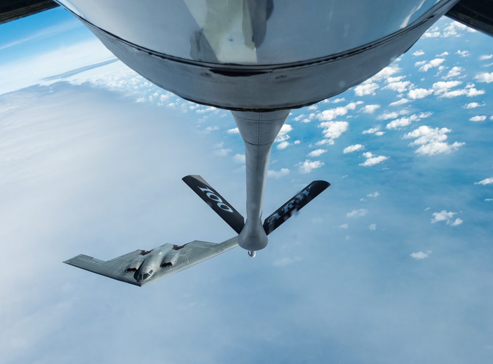 A B-2 Bomber and a KC-135 Stratotanker fly over England during a training mission