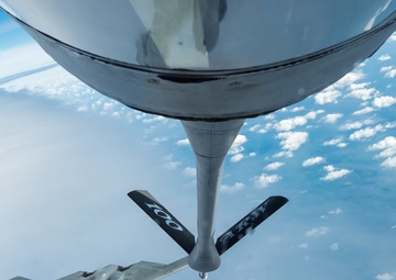 A B-2 Bomber and a KC-135 Stratotanker fly over England during a training mission