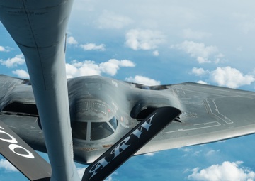 A B-2 Bomber and a KC-135 Stratotanker fly over England during a training mission