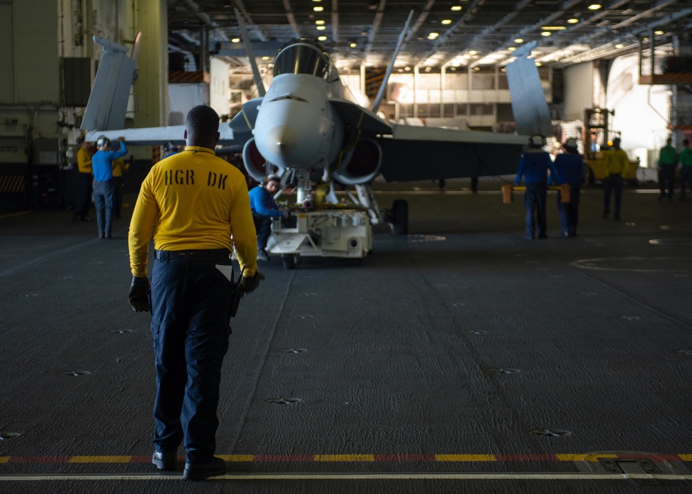 U.S. Navy Sailor guides a training aircraft